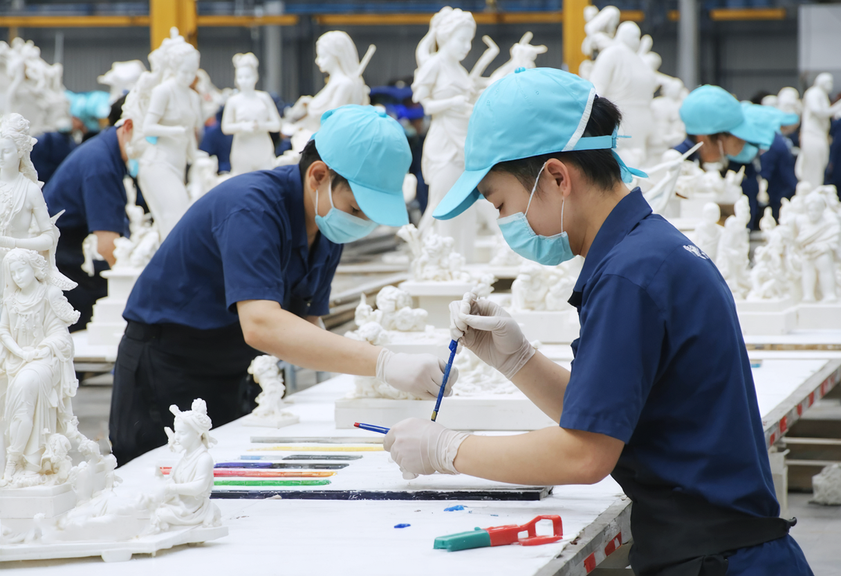 alt="workers producing resin crafts"